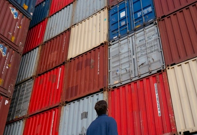 Person stood in front of shipping containers