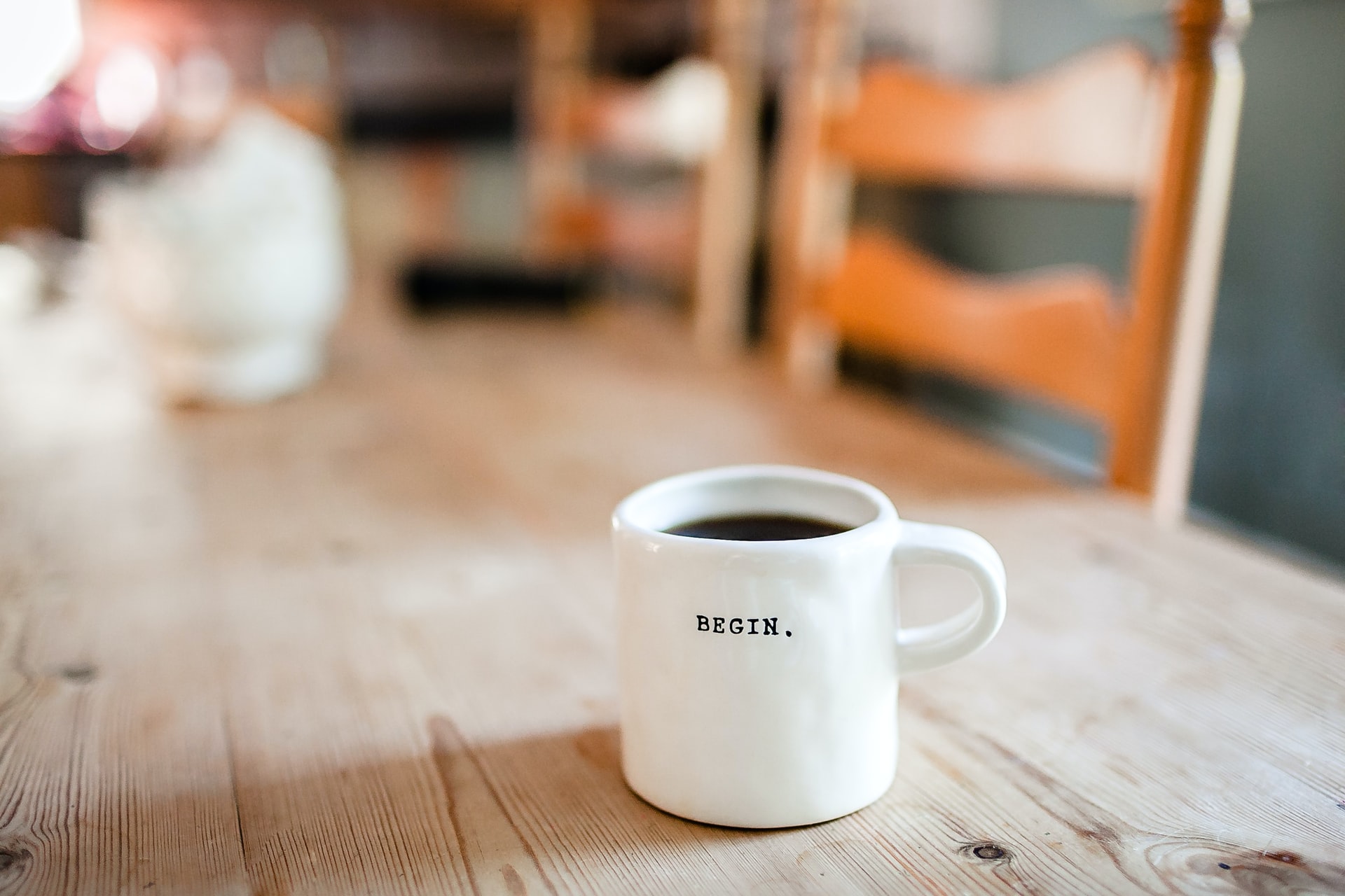 Coffee mug on a kitchen table labelled with begin 